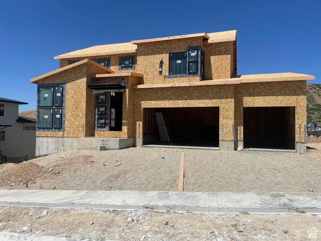 Property under construction featuring a garage and driveway
