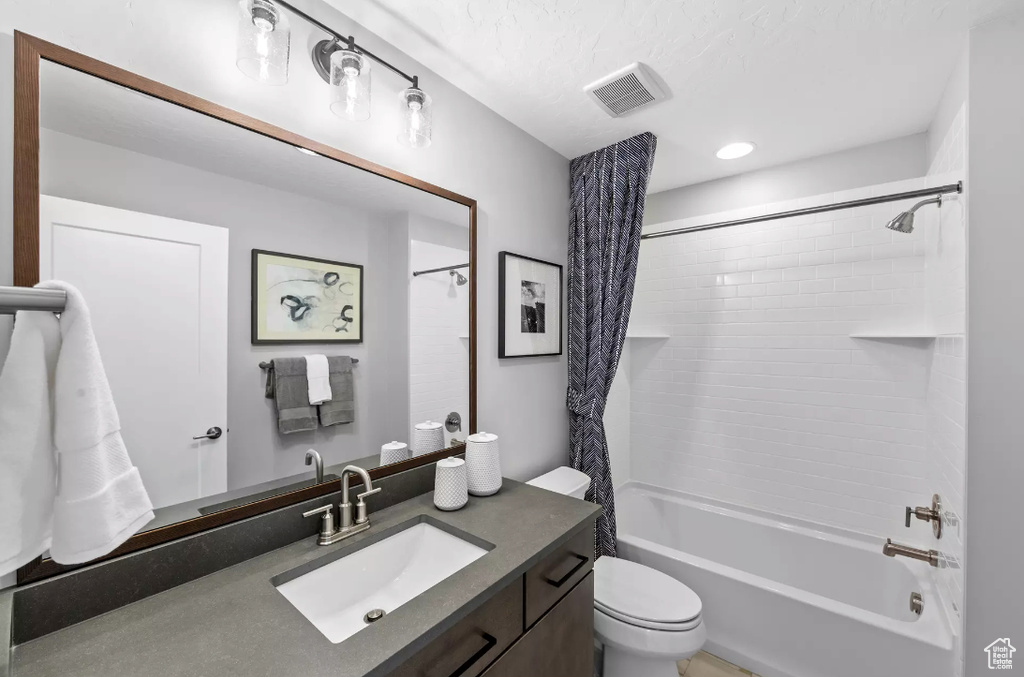 Full bathroom featuring shower / bathtub combination with curtain, vanity, and toilet