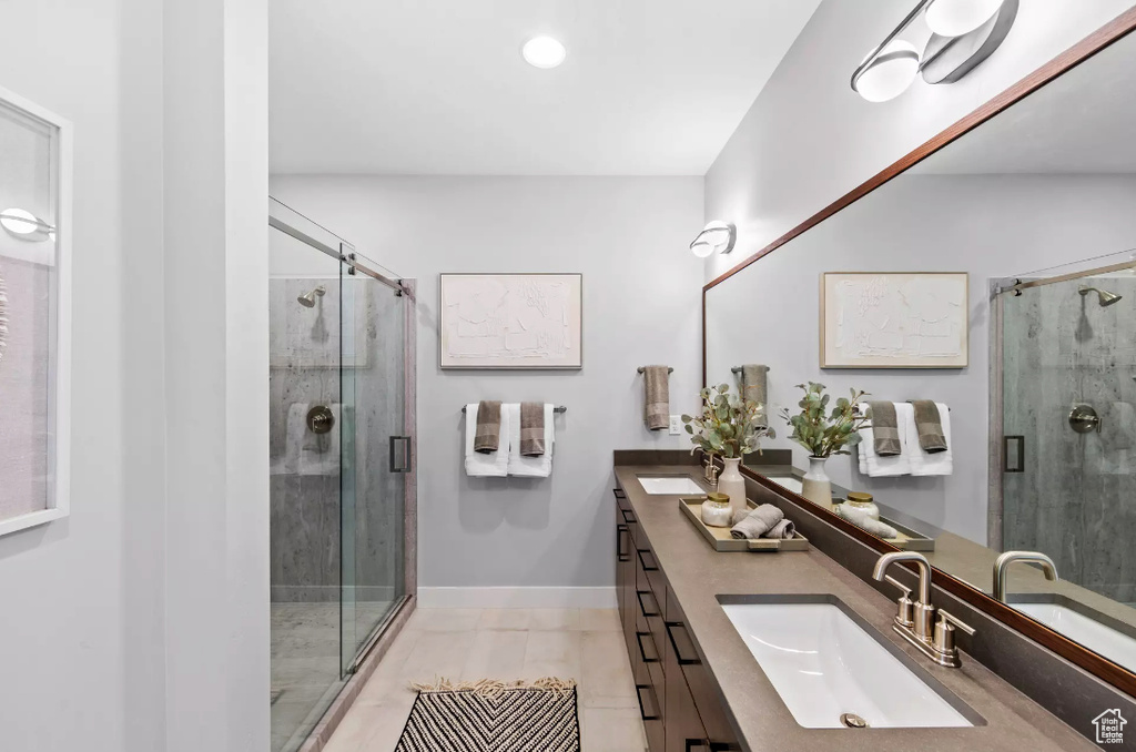 Bathroom with double vanity, a shower stall, tile patterned flooring, baseboards, and recessed lighting