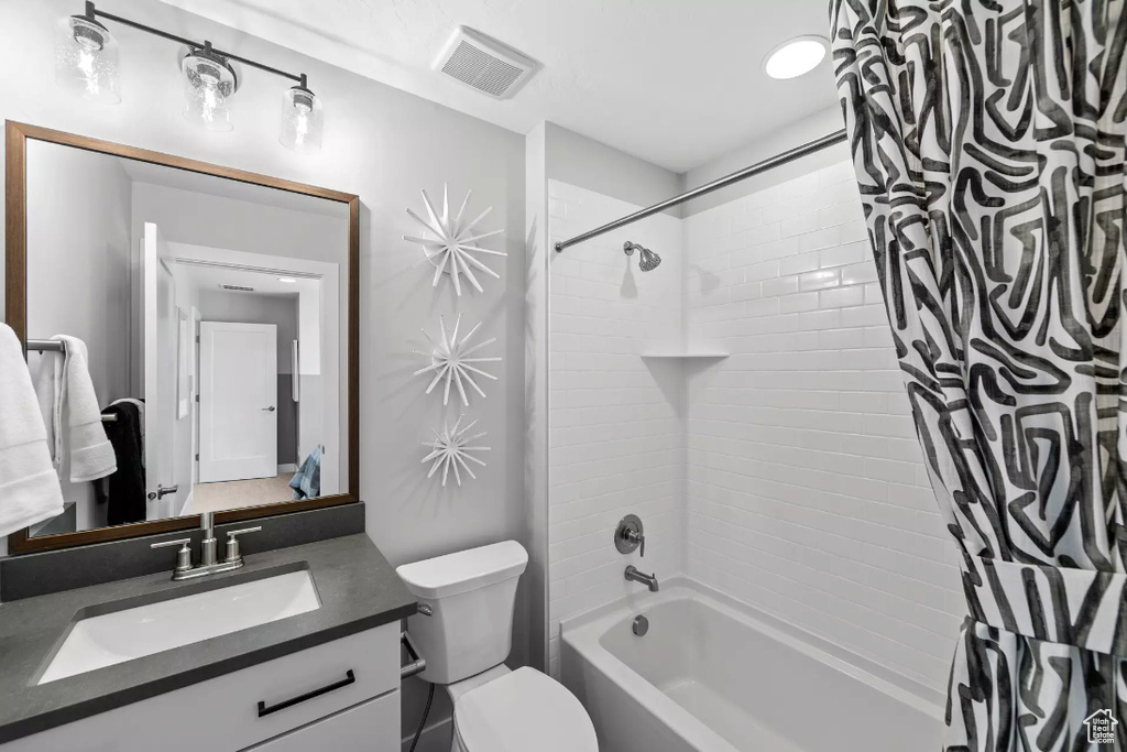 Full bath featuring shower / bath combo, vanity, and toilet