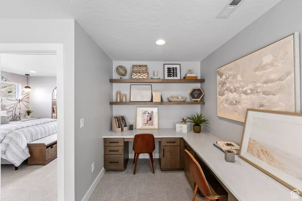 Office area featuring built in desk, light colored carpet, baseboards, and recessed lighting