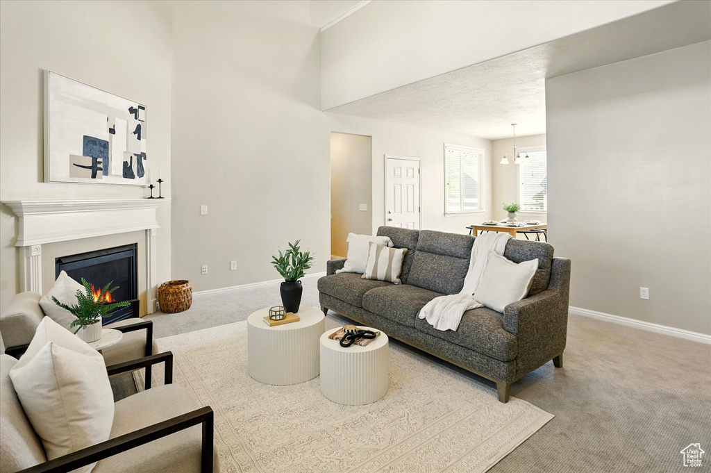 Carpeted living area featuring baseboards and a glass covered fireplace