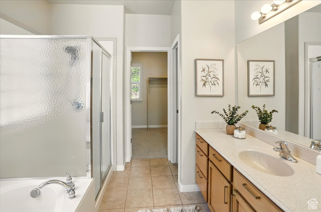 Full bathroom with a shower stall, vanity, tile patterned flooring, and baseboards