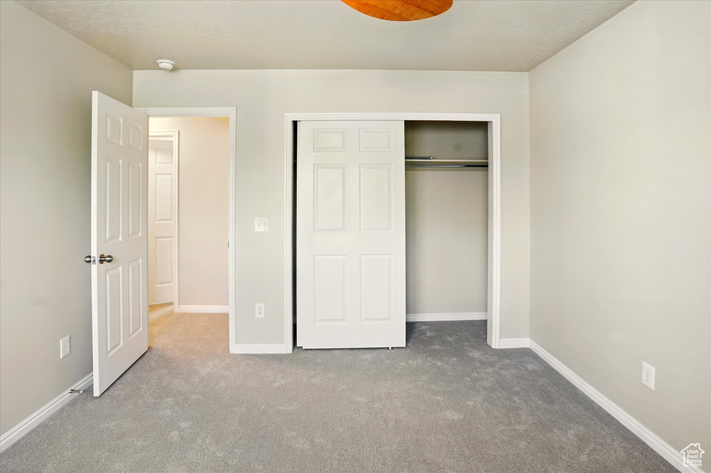 Unfurnished bedroom with carpet floors, baseboards, and a closet