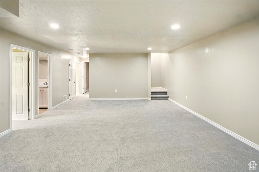 Finished basement with recessed lighting, baseboards, carpet flooring, and a textured ceiling