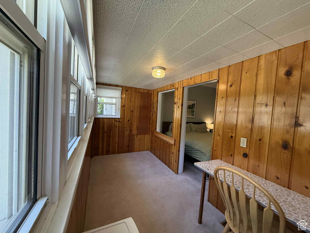 Hallway featuring carpet and wood walls