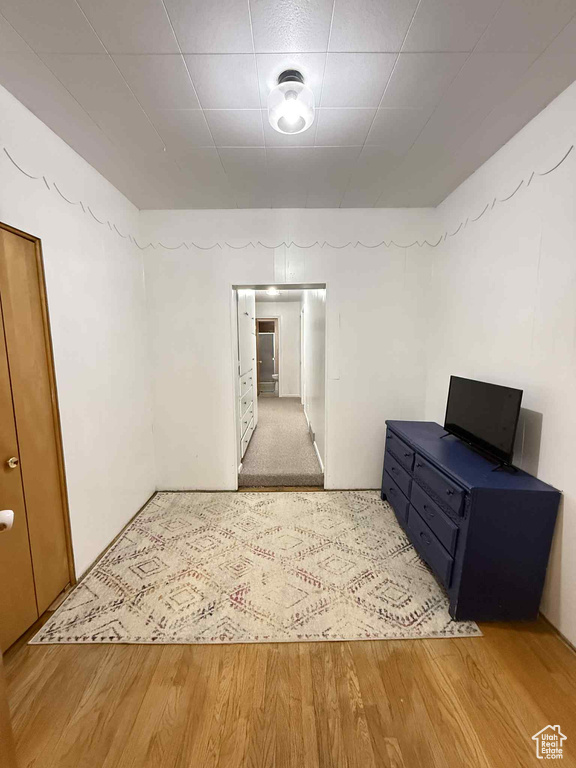 Empty room featuring light wood-style floors and a drop ceiling