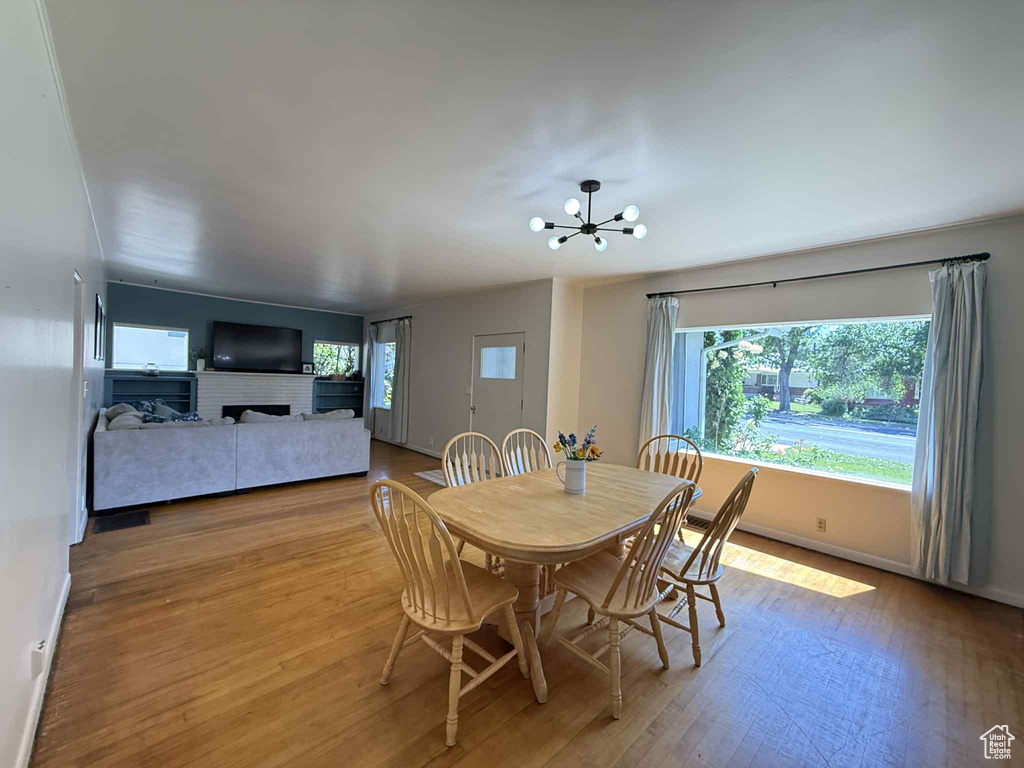 Dining space featuring wood finished floors, a chandelier, and baseboards
