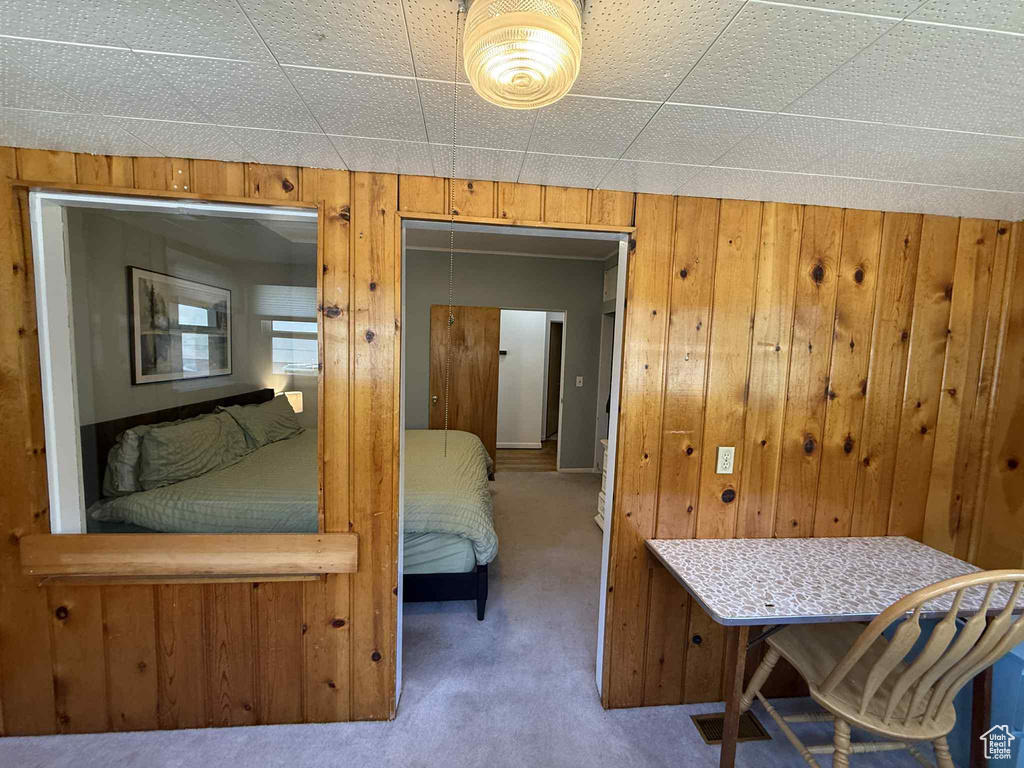 Bedroom featuring carpet and wood walls