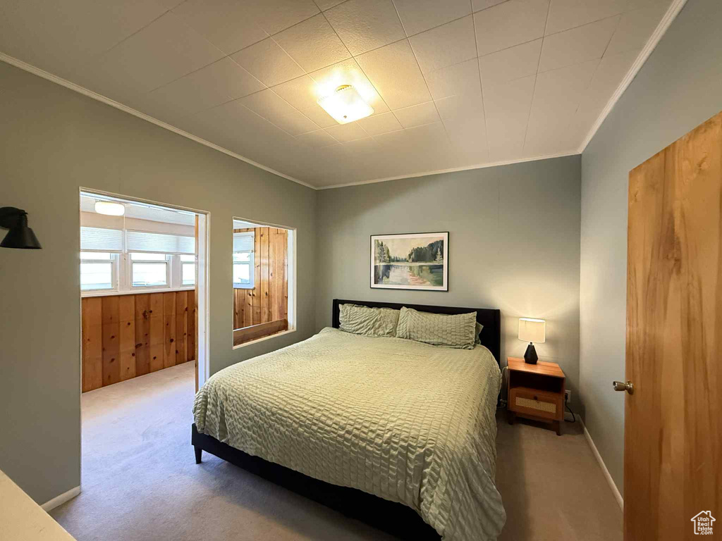 Bedroom with ornamental molding and carpet floors