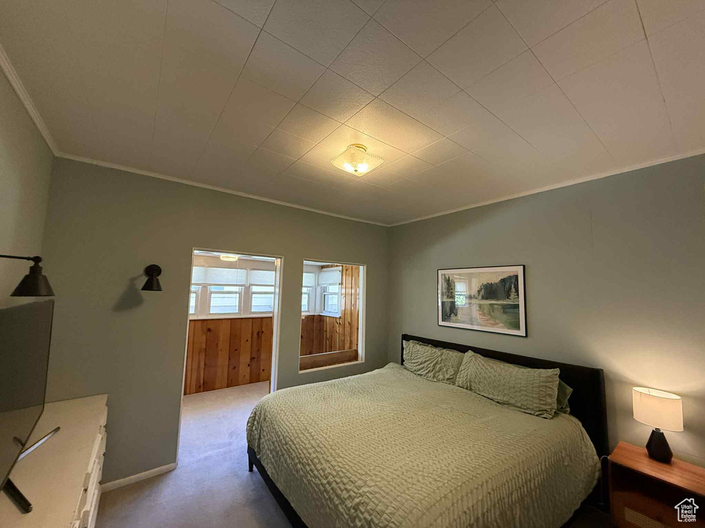 Bedroom with crown molding and carpet floors