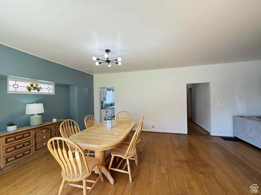 Dining space featuring a chandelier, wood finished floors, and baseboards