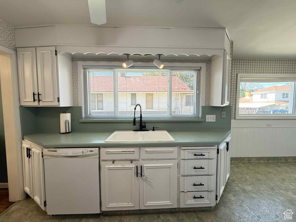 Kitchen featuring dishwasher, a sink, white cabinetry, ceiling fan, and light countertops