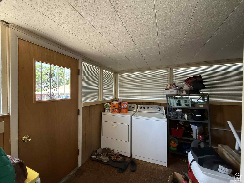 Laundry area with washer and dryer, carpet flooring, and wood walls