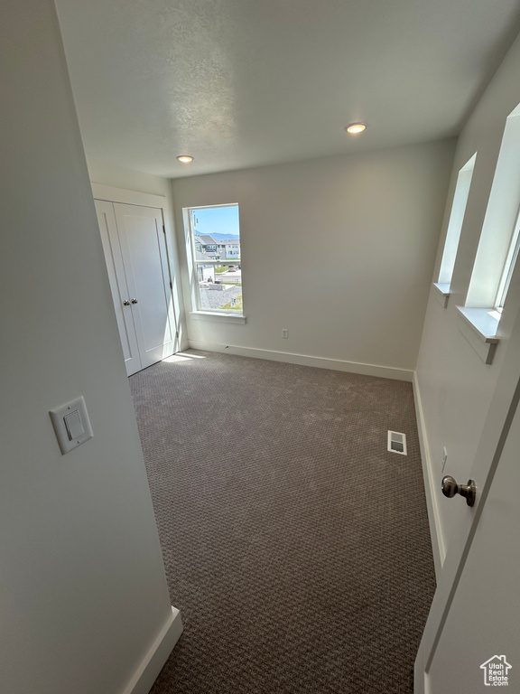 Carpeted empty room with baseboards and recessed lighting