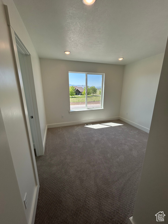 Carpeted spare room featuring recessed lighting, baseboards, and a textured ceiling