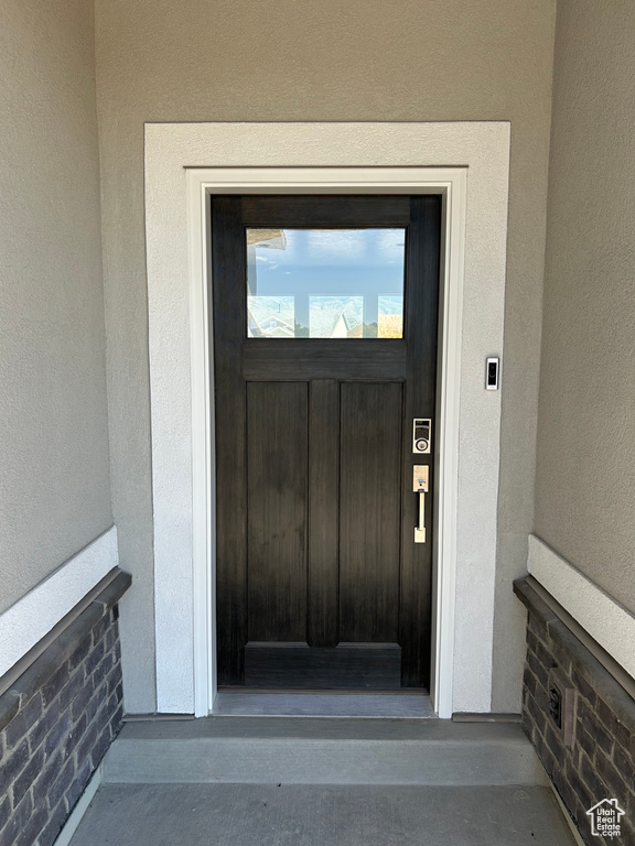 Doorway to property featuring stucco siding