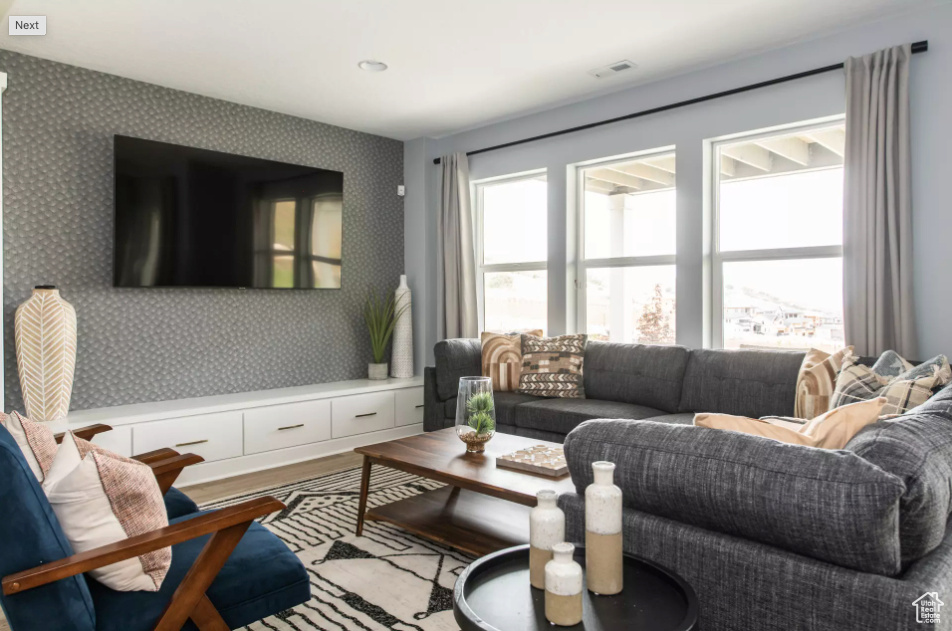 Living area featuring wallpapered walls and wood finished floors