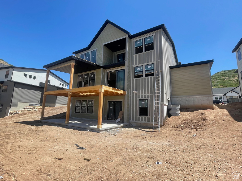 Back of property with a patio and board and batten siding