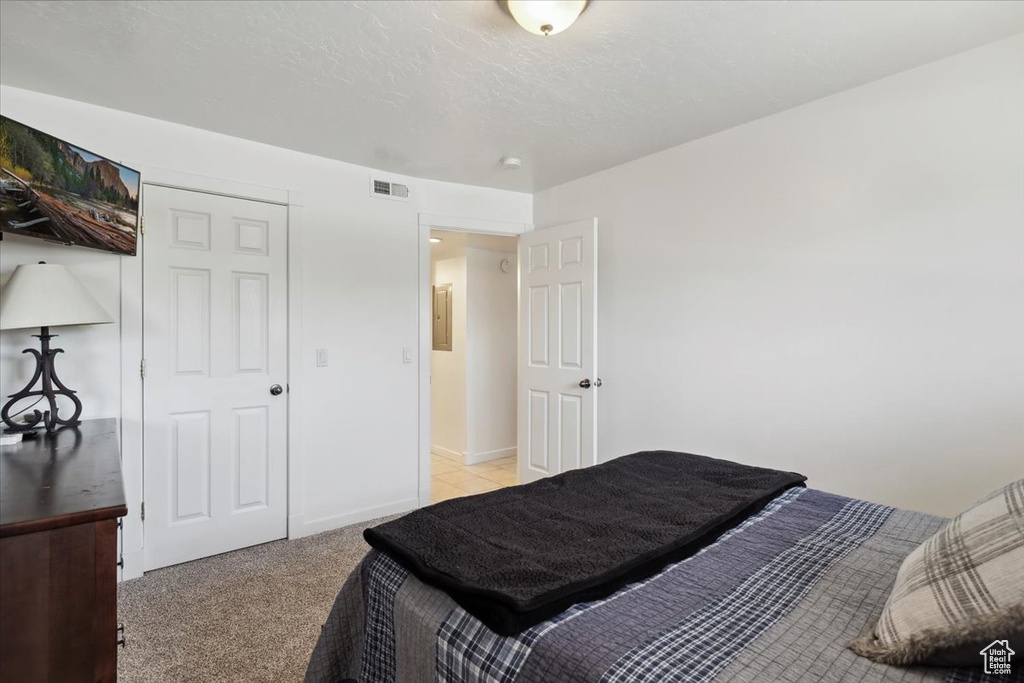 Bedroom featuring light carpet