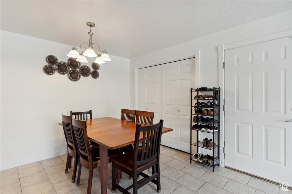 Dining room featuring a chandelier, light tile patterned flooring, and baseboards