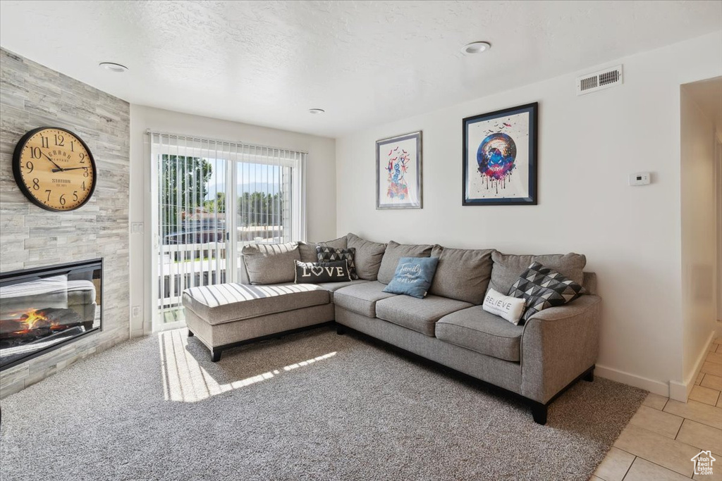Living room with light tile patterned flooring, a fireplace, and baseboards