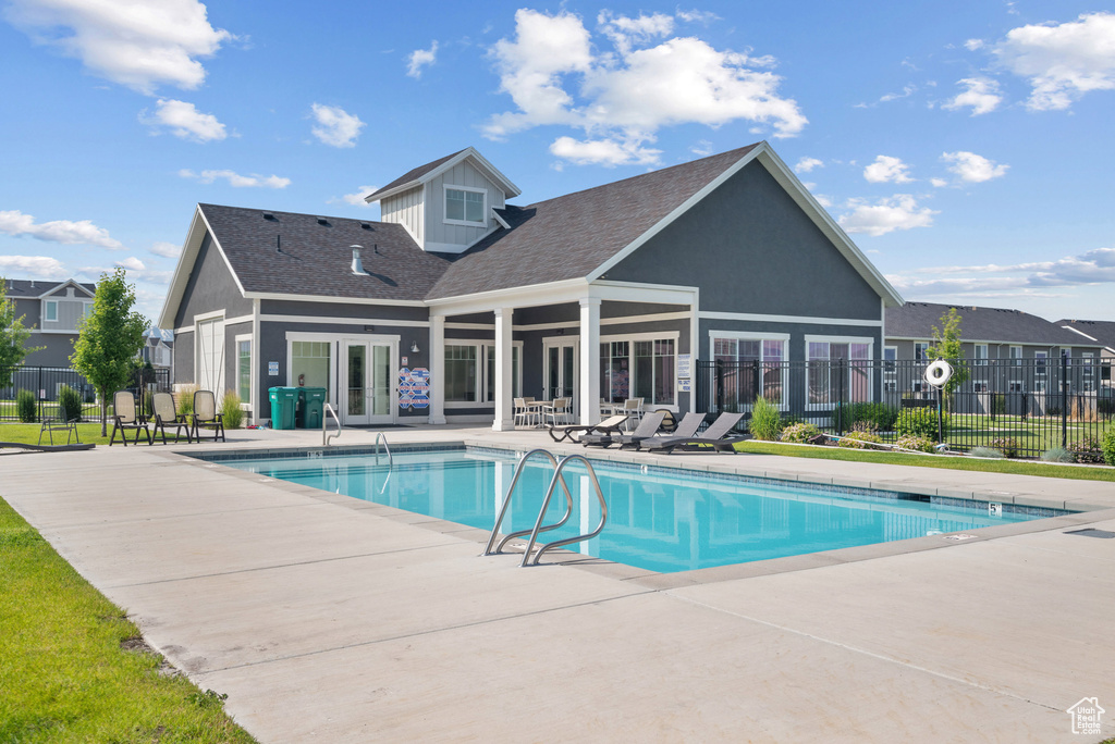 Community pool with a patio area and french doors