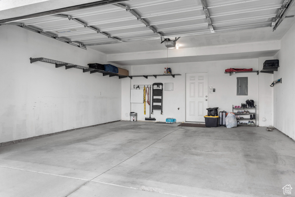 Garage featuring electric panel and a garage door opener