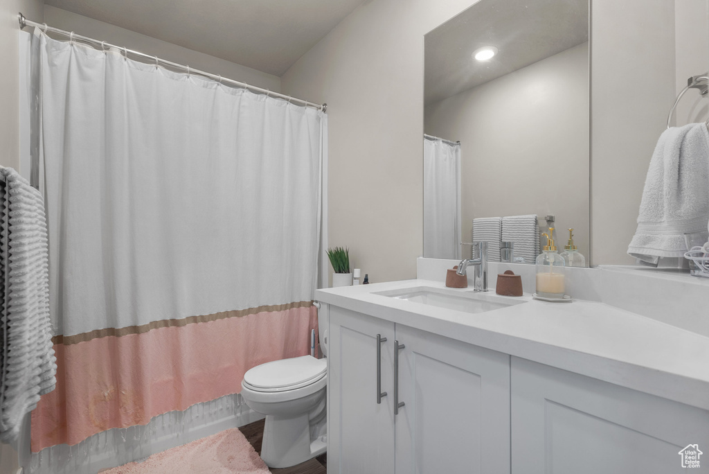 Full bath with toilet, vanity, and recessed lighting