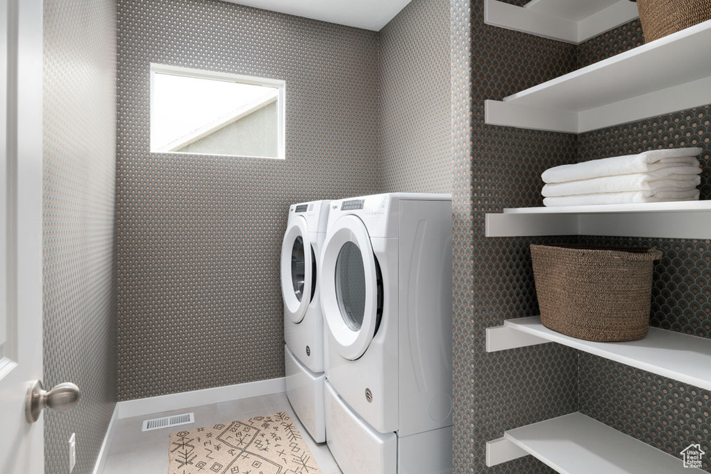 Washroom featuring washing machine and dryer and light tile patterned floors