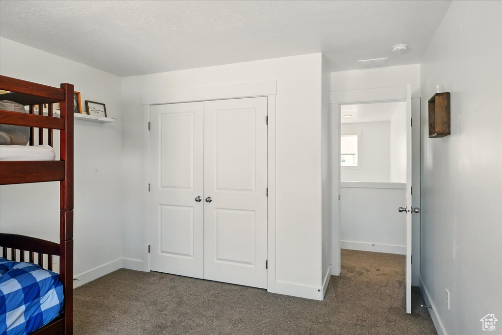 Unfurnished bedroom with carpet flooring, a closet, and baseboards