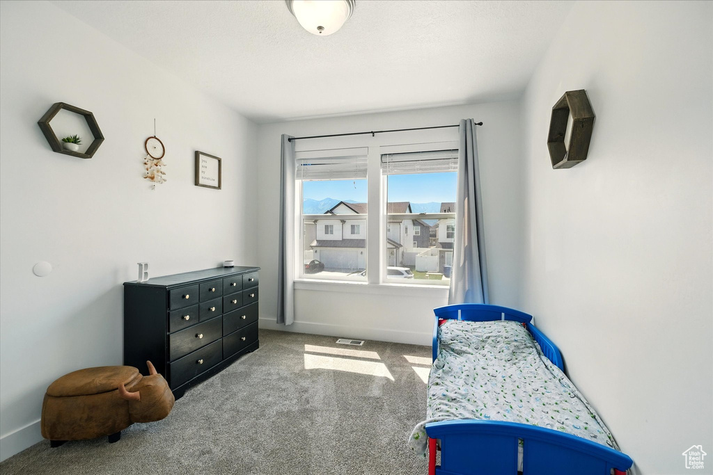 Bedroom featuring carpet and baseboards