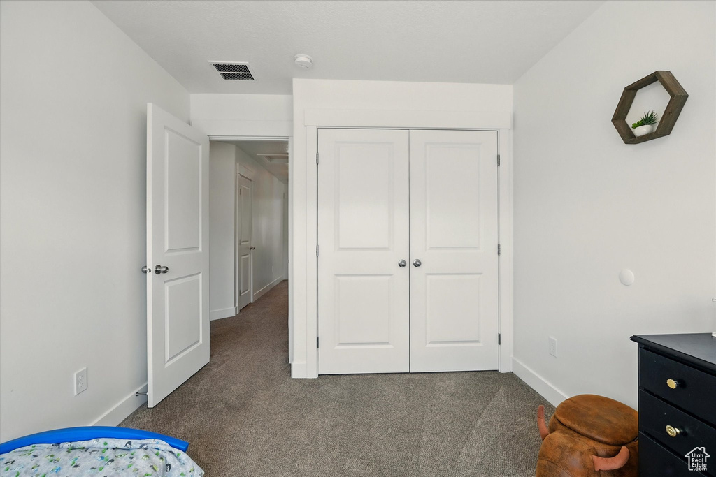 Carpeted bedroom featuring baseboards and a closet