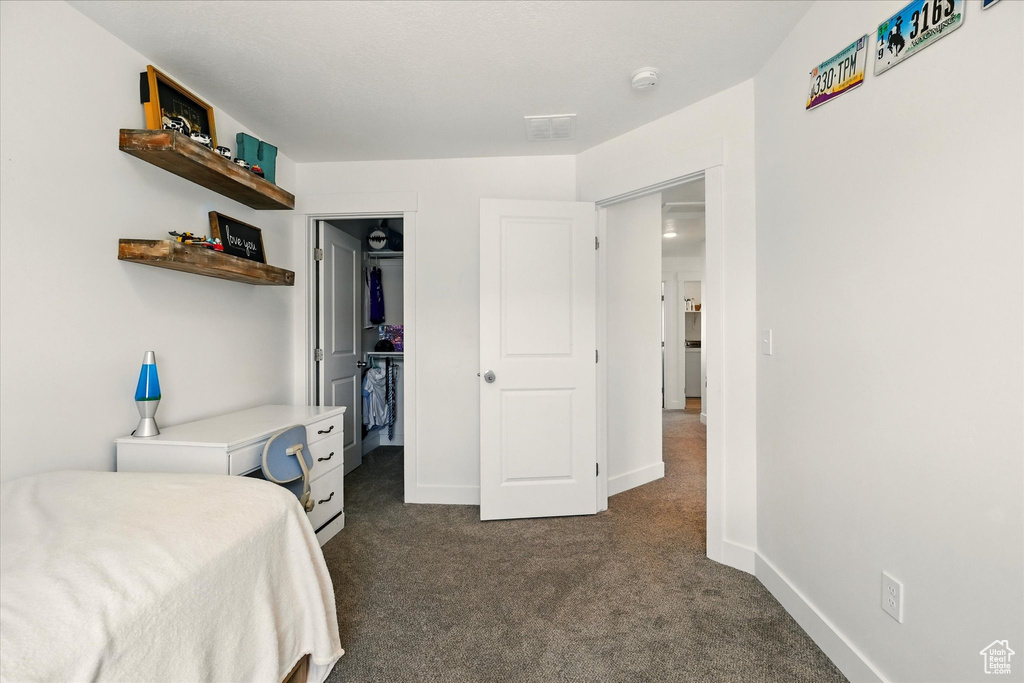 Bedroom featuring dark carpet and baseboards