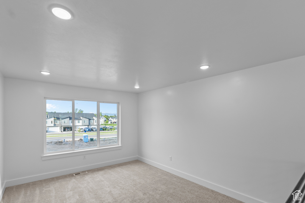 Spare room featuring baseboards, light carpet, recessed lighting, and a residential view