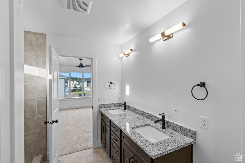 Full bath featuring double vanity, tile patterned flooring, and ceiling fan