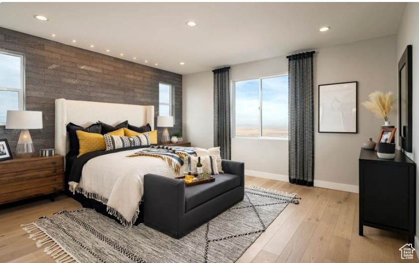 Bedroom featuring baseboards, recessed lighting, an accent wall, and light wood-type flooring