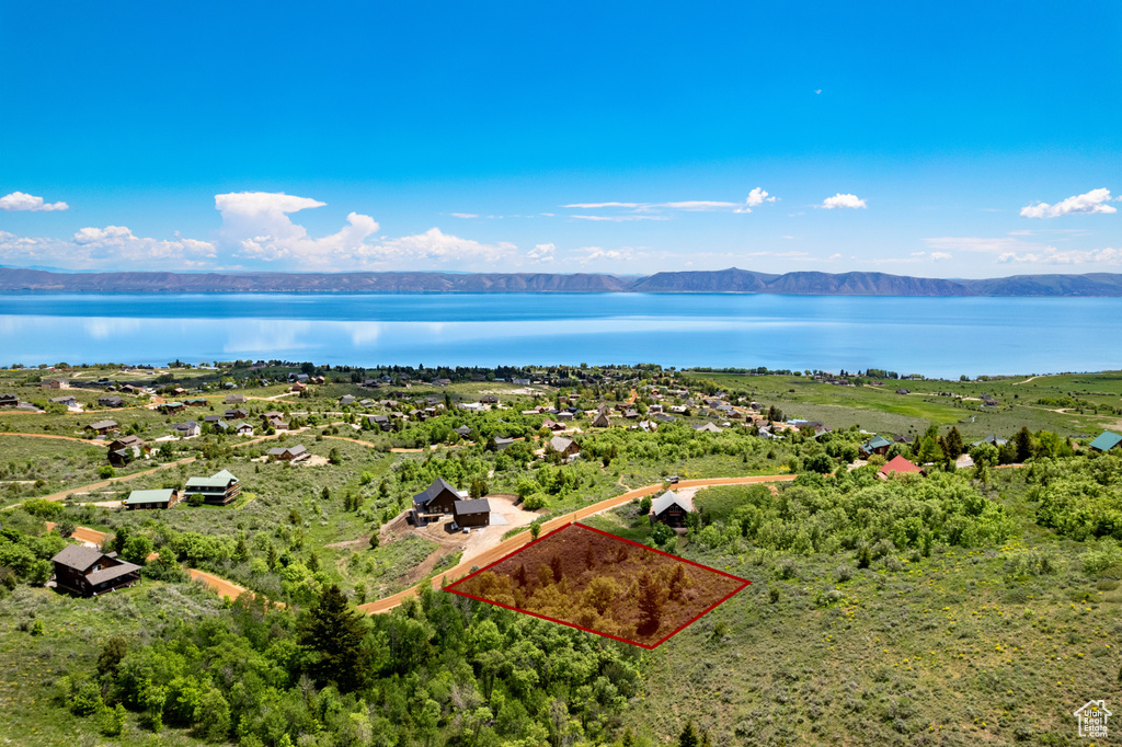 Aerial view of property and surrounding area featuring a water and mountain view and property parcel outlined