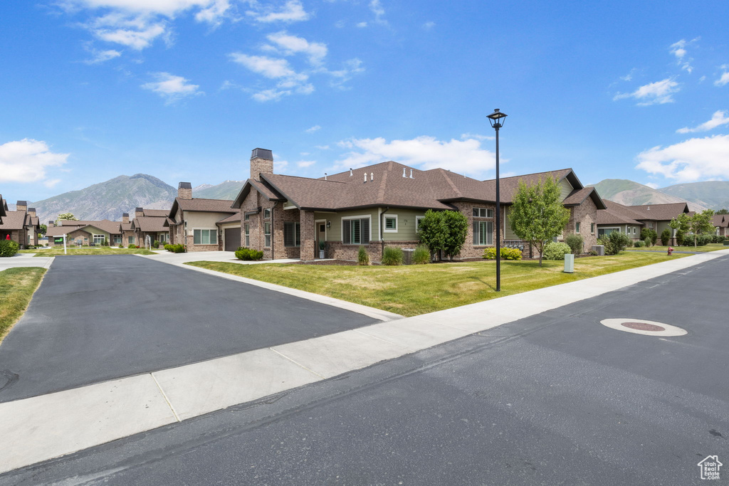 View of front facade featuring a mountain view, a residential view, and brick siding