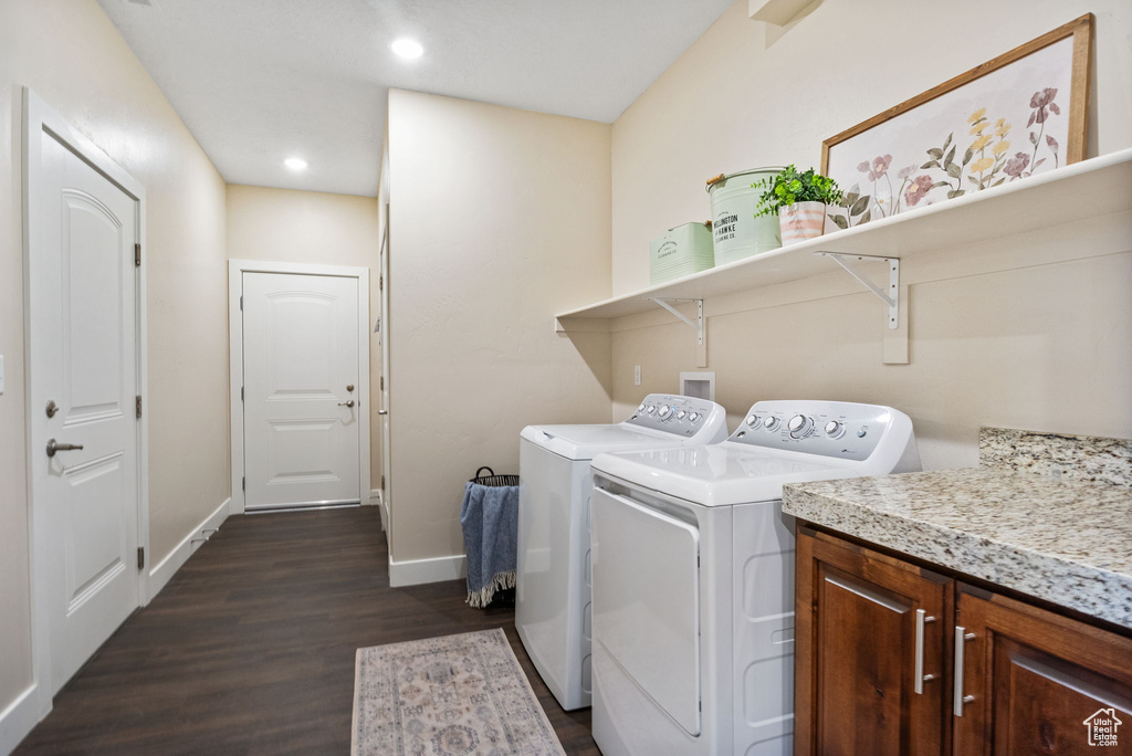 Laundry area featuring dark wood-style floors, baseboards, independent washer and dryer, recessed lighting, and cabinet space