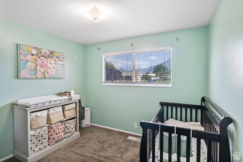 Bedroom with carpet, a nursery area, and baseboards