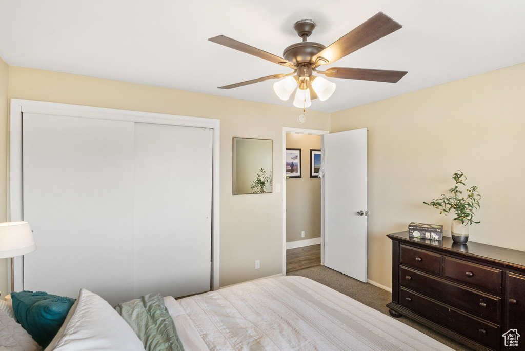 Carpeted bedroom featuring a closet, baseboards, and ceiling fan