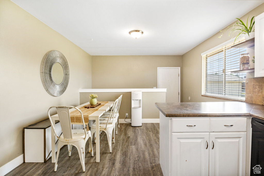 Dining area featuring dark wood-type flooring and baseboards