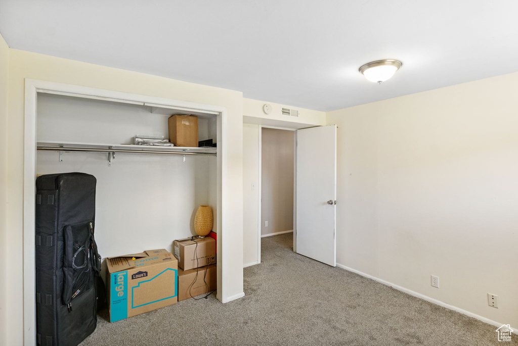 Bedroom featuring carpet floors, a closet, and baseboards