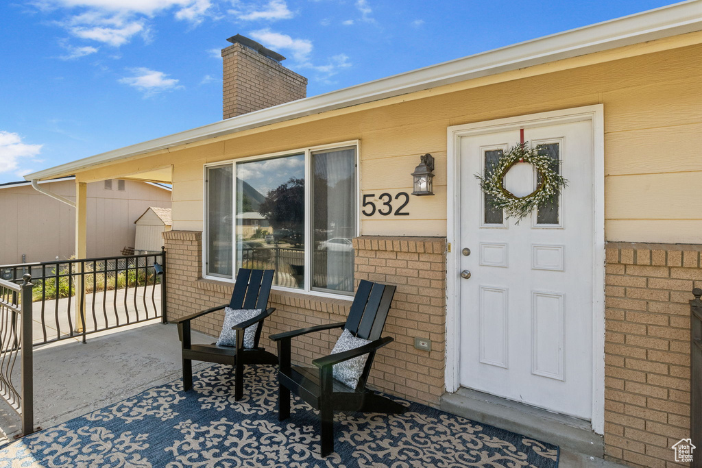 Doorway to property featuring brick siding and a chimney