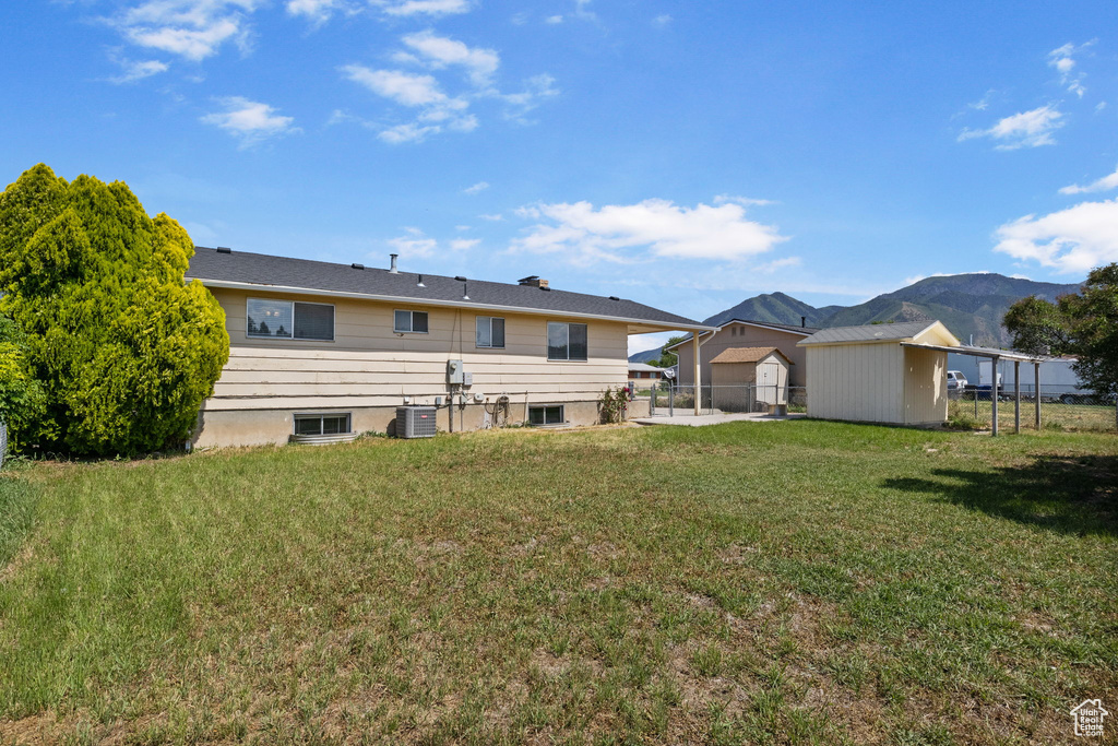 Rear view of house with central AC unit and a mountain view
