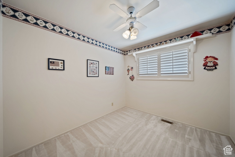 Carpeted empty room with ceiling fan