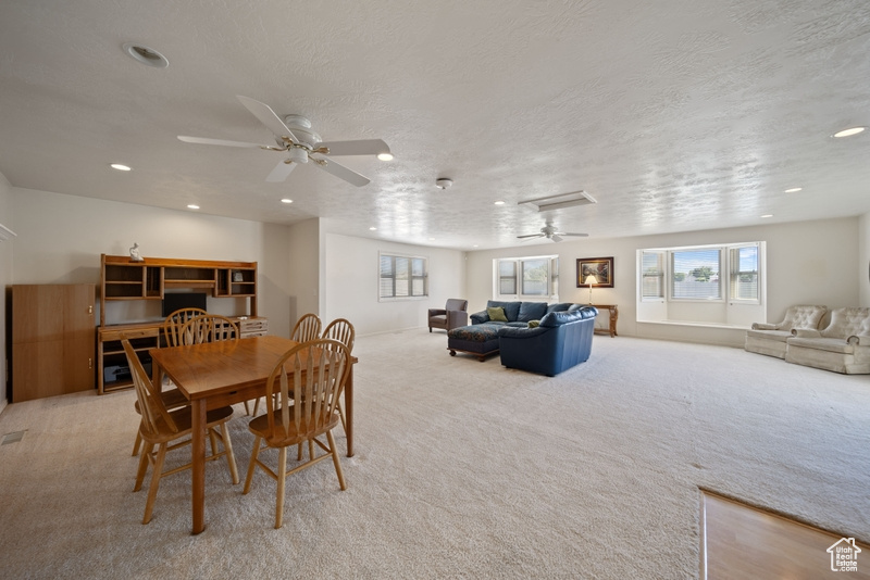 Carpeted dining area with ceiling fan, recessed lighting, and a textured ceiling