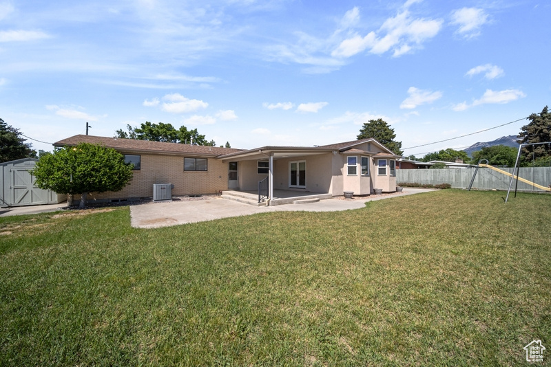 Rear view of house with a patio area and central AC