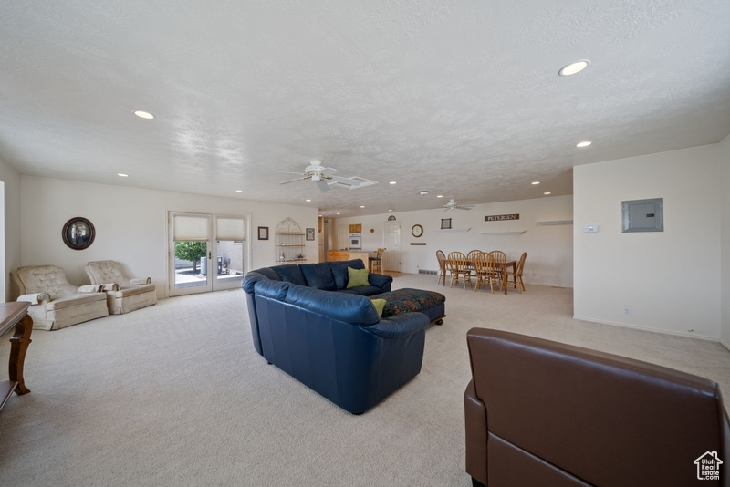 Living room featuring carpet, recessed lighting, ceiling fan, and electric panel